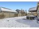 Snowy backyard with a covered patio and fenced area at 5232 Truckee St, Denver, CO 80249