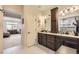 Double vanity bathroom with dark brown cabinets and a view into the bedroom at 5232 Truckee St, Denver, CO 80249