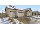 Beige house with double attached garage and snowy front yard at 5232 Truckee St, Denver, CO 80249