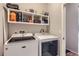 Laundry room with washer, dryer, and overhead shelving at 5232 Truckee St, Denver, CO 80249