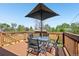 Back deck with umbrella, table, and chairs with a brown railing at 3491 Kassler Pl, Westminster, CO 80031