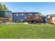 Spacious backyard featuring a large deck, lush lawn, and garden beds perfect for outdoor living and gardening at 3491 Kassler Pl, Westminster, CO 80031