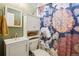 Well-lit bathroom with a floral shower curtain and white storage cabinet at 3491 Kassler Pl, Westminster, CO 80031