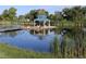 Scenic pond featuring a gazebo on an island, a footbridge, and lush vegetation at 3491 Kassler Pl, Westminster, CO 80031