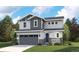 Charming two-story home with a gray garage door, blue front door, a welcoming porch, and professional landscaping at 8295 Snake River St, Littleton, CO 80125