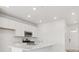 Bright kitchen featuring stainless steel appliances, white cabinets and an island with quartz countertops at 8295 Snake River St, Littleton, CO 80125