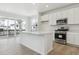 Bright kitchen with stainless steel appliances, white cabinets and an island with quartz countertops at 8295 Snake River St, Littleton, CO 80125