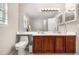 Bathroom with double sink vanity with dark wood cabinets, white countertop, and a large mirror at 21851 Omaha Ave, Parker, CO 80138