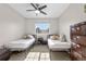Neutral toned bedroom with two twin beds, ceiling fan, and a window at 21851 Omaha Ave, Parker, CO 80138