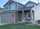 Charming two-story home with a covered front porch, brick accents, and an attached garage at 21851 Omaha Ave, Parker, CO 80138