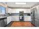 Modern kitchen featuring stainless steel appliances, grey backsplash, and hardwood floors at 21851 Omaha Ave, Parker, CO 80138