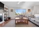 Relaxing living room with fireplace, bright window, and cozy seating on an area rug at 21851 Omaha Ave, Parker, CO 80138