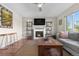 Inviting living room features a fireplace, TV, decorative shelving, and comfortable seating at 21851 Omaha Ave, Parker, CO 80138