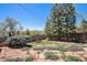 Landscaped backyard featuring stone pathways, lush greenery, a brick fence and mature trees at 6305 Yukon St, Arvada, CO 80004