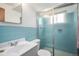 Full bathroom with glass door shower, blue tiling, and white sink and toilet at 6305 Yukon St, Arvada, CO 80004