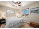 Cozy bedroom with ceiling fan, large window offering great natural light, and patterned window decor at 6305 Yukon St, Arvada, CO 80004