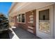 Brick exterior showcasing the home's entrance and front window with natural light at 6305 Yukon St, Arvada, CO 80004