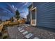 A beautifully landscaped backyard with decorative gravel, a stepping stone path, and lush greenery at 6309 N Hanover St, Denver, CO 80238