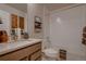 Bathroom features a single sink vanity with a shower-tub combo and white tiled walls at 6309 N Hanover St, Denver, CO 80238