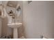 Stylish half bath featuring pedestal sink and decorative mirror at 6309 N Hanover St, Denver, CO 80238