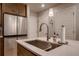 Close-up of kitchen island featuring stainless steel sink and fixtures at 6309 N Hanover St, Denver, CO 80238