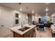Open concept kitchen with center island flowing into the dining and living area at 6309 N Hanover St, Denver, CO 80238