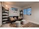 Cozy living room with a dark brown sofa, two stools, natural light, and decorative shelving at 6309 N Hanover St, Denver, CO 80238