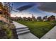 A lush neighborhood park provides a serene focal point, framed by colorful homes against a dramatic sky at 6309 N Hanover St, Denver, CO 80238