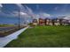 A beautifully maintained community green space bordered by sidewalks and colorful houses against a dramatic sky at 6309 N Hanover St, Denver, CO 80238