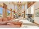 Spacious living room featuring a two-story stone fireplace and large windows at 10730 Pinewalk Way, Highlands Ranch, CO 80130