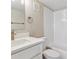 Bright bathroom featuring white vanity with quartz countertop, tub with white tiled walls, and modern fixtures at 381 S Ames St # E104, Lakewood, CO 80226