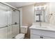 Bathroom showcasing glass enclosed shower, white vanity with quartz countertop, and modern lighting at 381 S Ames St # E104, Lakewood, CO 80226