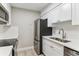 Close up view of modern kitchen featuring stainless steel appliances, white cabinets, and tile backsplash at 381 S Ames St # E104, Lakewood, CO 80226