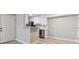 Bright kitchen area featuring white cabinets, stainless steel appliances, quartz countertop and light-colored hardwood floors at 381 S Ames St # E104, Lakewood, CO 80226