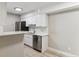 Modern kitchen with white cabinets, stainless steel appliances, quartz countertops, and light-colored hardwood floors at 381 S Ames St # E104, Lakewood, CO 80226