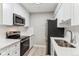 Bright kitchen featuring stainless steel appliances, quartz counters, and white cabinets at 381 S Ames St # E104, Lakewood, CO 80226