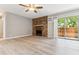 Bright living room featuring a stone fireplace, ceiling fan, balcony access, and hardwood floors at 381 S Ames St # E104, Lakewood, CO 80226