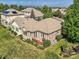 Aerial view of a house featuring a brick patio, a small deck, manicured landscaping and lots of windows at 14064 E Whitaker Dr, Aurora, CO 80015
