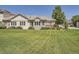Expansive backyard with lush lawn, mature trees, and a small deck area at 14064 E Whitaker Dr, Aurora, CO 80015