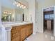 Bright bathroom with a sink, vanity, large mirror, and access to a walk-in closet at 14064 E Whitaker Dr, Aurora, CO 80015