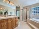 Elegant bathroom featuring a large vanity, walk-in shower, and a soaking tub for relaxation at 14064 E Whitaker Dr, Aurora, CO 80015