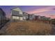 View of a fenced backyard with lawn area and a modern two-story home under a beautiful sunset sky at 16278 E 111Th Pl, Commerce City, CO 80022