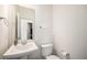 Bright half bathroom with pedestal sink, large mirror, and toilet with paper holder at 16278 E 111Th Pl, Commerce City, CO 80022