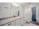 Bathroom with granite countertop, white cabinets, and shower with blue patterned curtain at 16278 E 111Th Pl, Commerce City, CO 80022