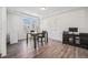 Bright dining area featuring wood floors, a modern chandelier, and a view of the neighborhood at 16278 E 111Th Pl, Commerce City, CO 80022