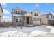 Charming two-story home with stone accents, an attached two-car garage, and snow-covered front yard at 16278 E 111Th Pl, Commerce City, CO 80022