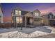 Inviting two-story home featuring stone accents, attached garage, and a cozy front porch, set against a colorful sunset backdrop at 16278 E 111Th Pl, Commerce City, CO 80022