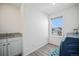 Bright laundry room features a sink with granite countertop, gray plank flooring and a window view at 16278 E 111Th Pl, Commerce City, CO 80022