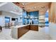 Modern community kitchen with wood accents, blue tile, and an island with seating at 4641 Windmill Dr, Brighton, CO 80601