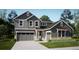 Two-story craftsman style home with gray siding, stone accents, and a three-car garage at 4641 Windmill Dr, Brighton, CO 80601